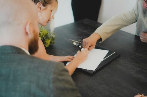 To personer underskriver en lejekontrakt ved et skrivebord